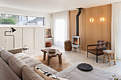 Wohnzimmer mit Kaminofen, Holzelementen und neutralen Farbtönen