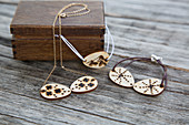 Necklace and bracelets with pendants made from discs of wood decorated with poker work