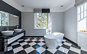 Modernes Bad mit freistehender Badewanne und schwarz-weißem Schachbrettmusterboden