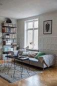 Slimline coffee tables and modern sofa against panelled wainscot