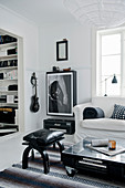 Wohnzimmer in Schwarz und Weiß mit Palettentisch und Gitarrenbild