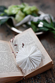 Small white paper rosette used as bookmark
