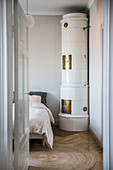 Round, Swedish tiled stove in bedroom