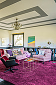 Upholstered furnishings and rug in shades of pink and purple in living room