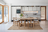 Wishbone Chairs around dining table in front of grey fitted kitchen