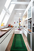 Küche mit grünem Teppich, Blick ins Wohnzimmer der Dachwohnung