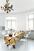 Golden tablecloth and chandelier in white dining room