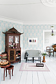 Antique cabinet, pale blue wallpaper and white floor in living room