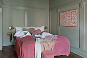 Panelled walls and pink accents in classic bedroom