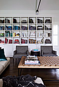 Colourful books in the living room with upholstered coffee table