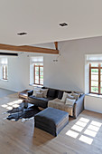Graues Sofa im minimalistischen Wohnzimmer im modernen Landhaus