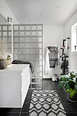 Modernes Bad in Schwarz-Weiß mit Trennwand aus Glasbausteinen