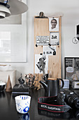 Kamera, Becher und Klemmbrett mit Postkarten auf dem Schreibtisch