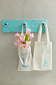 Hand-sewn cloth bags hung from DIY pegs made from wooden board and furniture knobs