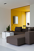 Grey sofa in modern, architect-designed house with yellow alcove