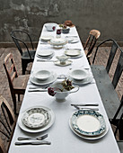 View along table set with white tablecloth and various chairs