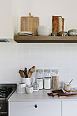 Kitchen accessories in natural tones in a simple kitchen with shelves