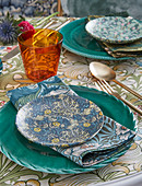 Table set with various floral patterns in shades of blue and green