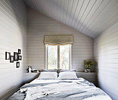 Doppelbett im Zimmer mit Dachschräge
