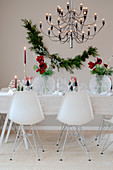 Designerstühle am gedeckten Tisch zu Weihnachten mit Amaryllis