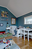 White furniture in child's bedroom with blue walls and sloping ceiling