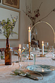 Gedeckter Tisch im Boho-Stil mit Kerzen in goldenen Kerzenhaltern
