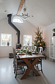 Festively set wooden table in dining room with high ceiling
