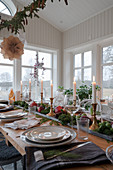Centerpiece mit Kerzen, Granatäpfeln und Gemüse auf gedecktem Tisch