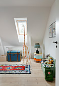 Giraffe and flea-market furniture in child's bedroom with sloping ceiling
