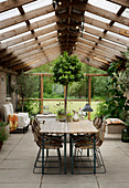 Two beer-garden tables used as dining table in simple conservatory