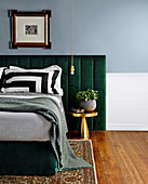 Double bed with headboard upholstered in green fabric