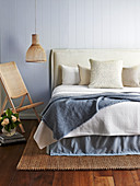 Bettkopfteil mit beigefarbenem Bezug am Doppelbett