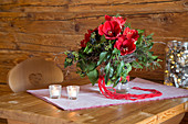 Bouquet with red amaryllis, ivy and ivy berries on wooden table