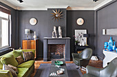 Various seating and fireplace in living room with dark grey walls