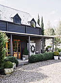 Gravel forecourt and wooden house with veranda