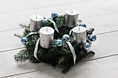 Handmade Advent wreath with silver candles and blue Christmas-tree baubles