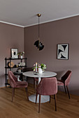 Velvet-covered chairs around round table in dining room in earthy shades