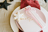 Christmas place setting with party favour and snowflake-shaped biscuit