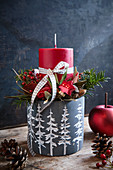 Festive arrangement with red candle in grey flower pot