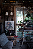 Painted portrait of a man next to a sitting area in a rustic shed