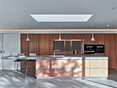 Wooden designer kitchen with concrete worksurface on island counter