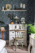 Antique bureau in writing corner of bedroom with blue-patterned wallpaper