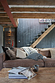 Rustikales Wohnzimmer in Grau und Braun mit Metalltreppe auf Balken