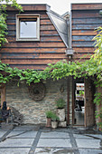Modernes Landhaus mit Natursteinwand und Holzverkleidung