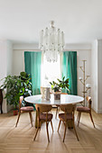 Retro chairs at round table in classic dining room with chandelier