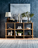 Shelf with decorative accessories in front of blue wall with picture