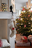 Nikolaussocken an Konsole gehängt, Weihnachtsbaum im Hintergrund