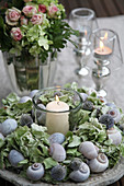 Tealight in wreath of globe thistles, hydrangeas and snail shells