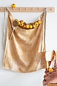 Apron and garland of apples hanging from coat pegs