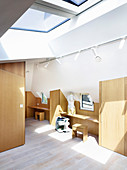 Study on first floor with custom wooden furnishings and skylights